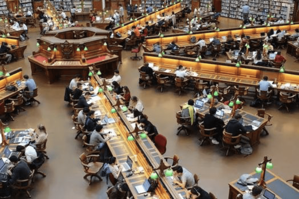 People studying in a large library hall.