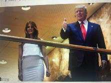 Man and woman standing, man giving thumbs up.